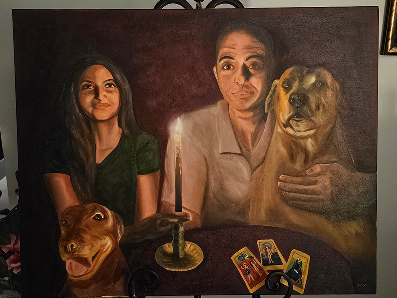Artist Karla Del Valle’s painting, entitled “The Séance,” is featured in the “In the Dark” exhibition. The painting is a family portrait of Del Valle’s husband, daughter, and their two dogs at a séance table with three tarot cards on display.. (Photo by Karla Del Valle)