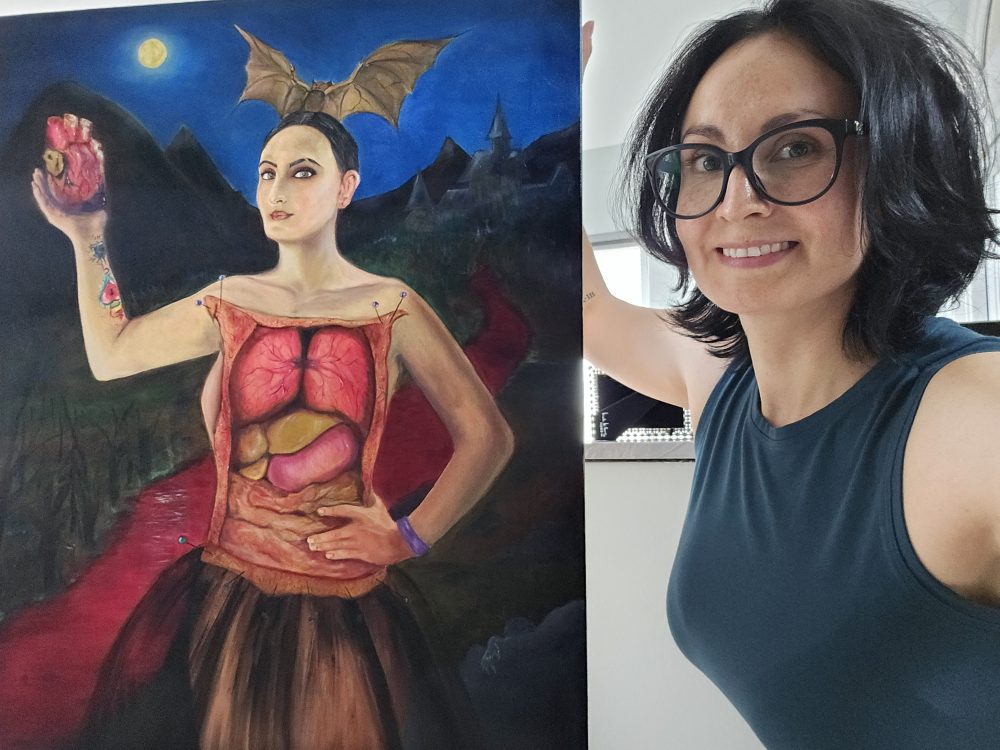 Karla Del Valle, next to her self-portrait entitled “The Bloofer Lady.” The painting was inspired by her work as a crime scene investigator and her love for vampire lore. (Photo by Karla Del Valle)