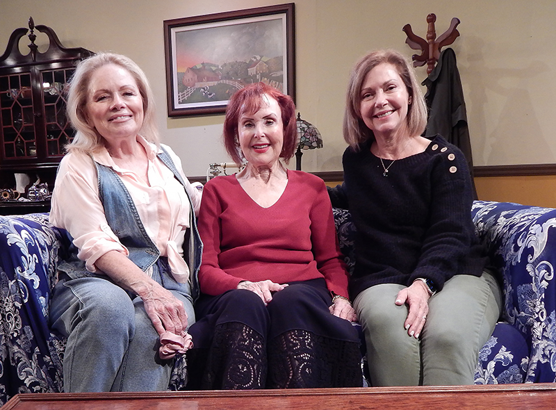 From left, Deborah Kondelik, who is directing Pigs Do Fly’s current production, starred as May in the 2024 Pigs Do Fly Production of Norm Foster’s “The Affections of May.” The play was directed by Mariah Reed, right, and produced by Ellen Wacher, center. (Photo by Carol Kassie)