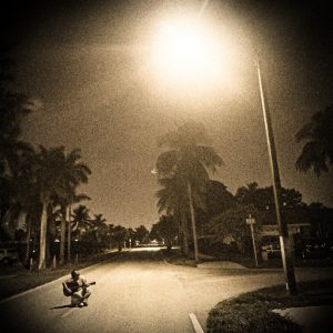 Timothy LaRoque "The Florida Effect" album cover featuring LaRoque crouching on nighttime street lined with palm trees under bright streetlight